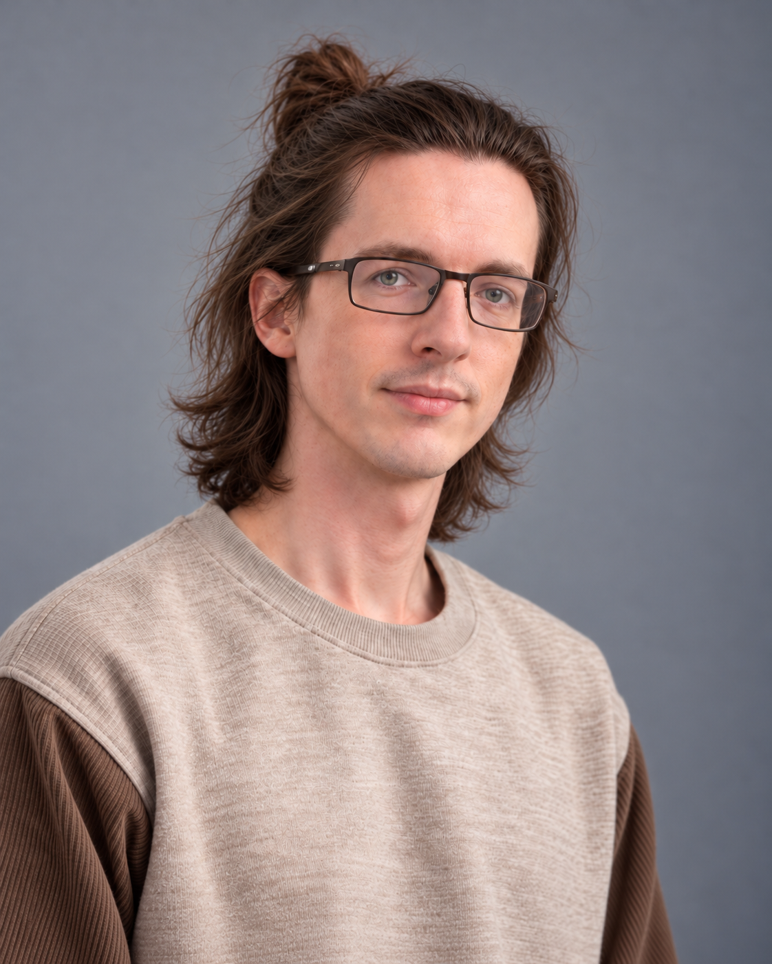 Portrait of Tristan Ratliff wearing glasses against a neutral background